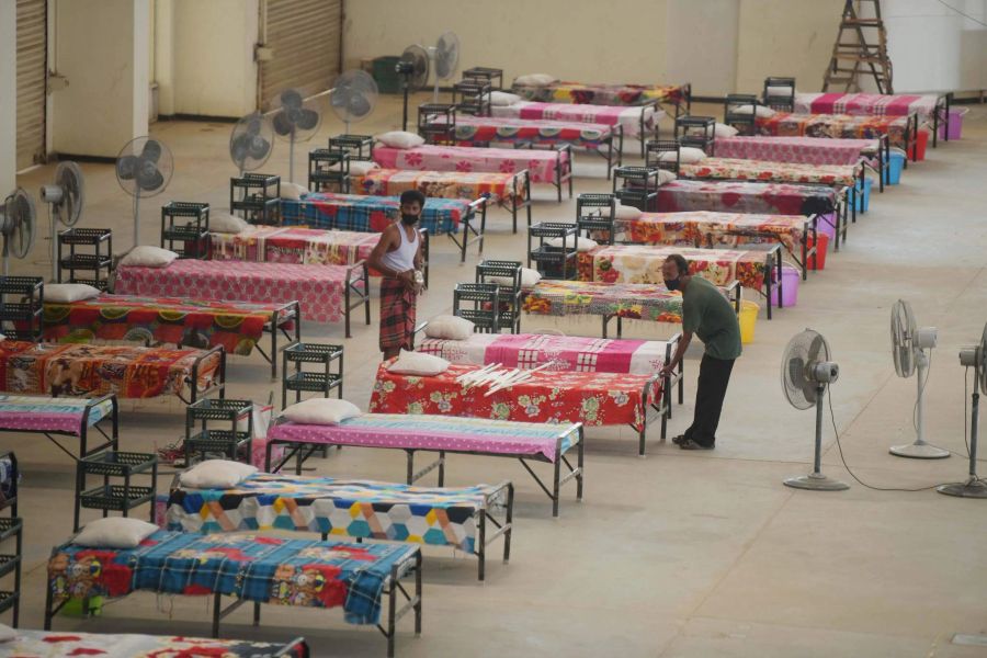 Mitarbeiter stellen in einem Quarantänezentrum für Corona-Infizierte auf dem Gelände der Hapania International Fair am Stadtrand von Agartala im Bundesstaat Tripura Betten auf.