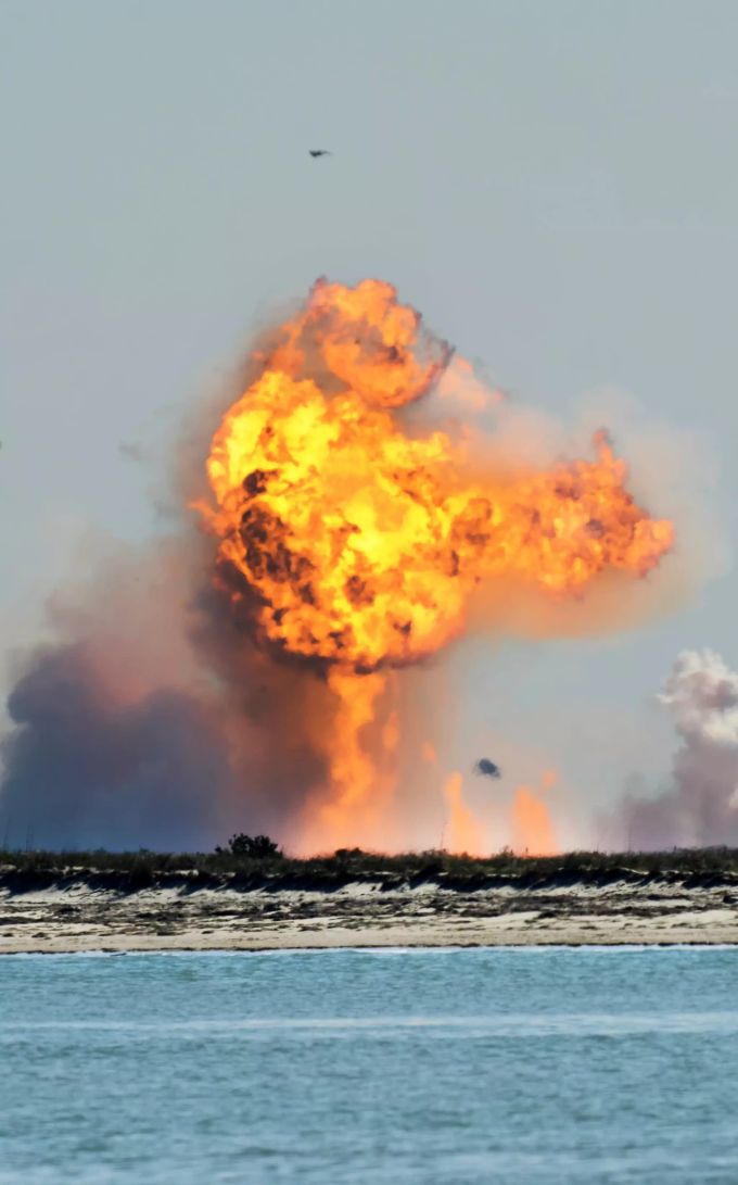 SpaceX Rakete explodiert: Das Bild zeigt ein Versuch vom Februar. Der kugelförmige Starship-Prototyp geht nach dem Absturz beim Versuch, nach einem erfolgreichen Teststart zu landen, in Flammen auf. SpaceX