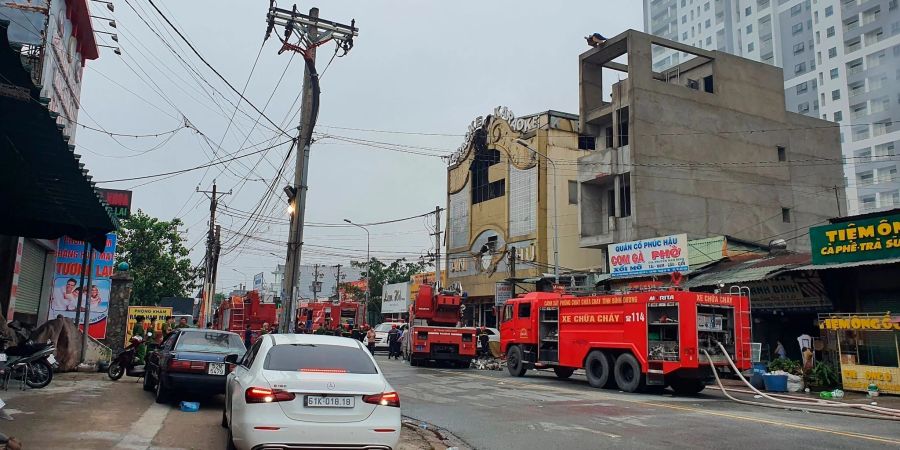 Feuerwehrfahrzeuge stehen nach einem Brand im Süden Vietnams vor der Karaokebar.