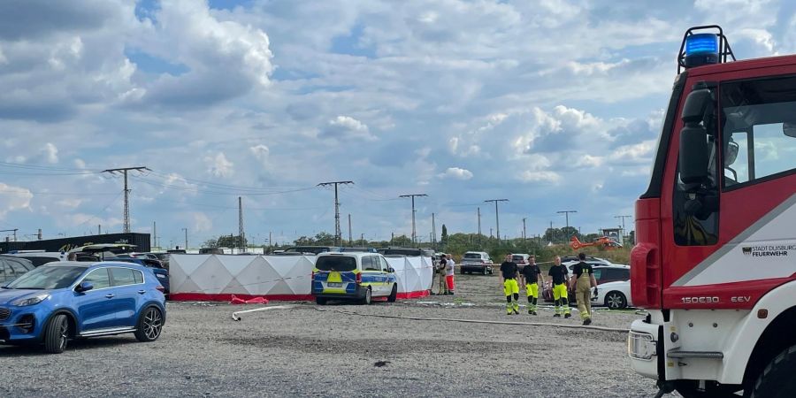 Mit Sichtschutzwänden ist der Unfallort abgeschirmt, an dem ein Kleinflugzeug auf einen Zirkus-Parkplatz abgestürzt ist.