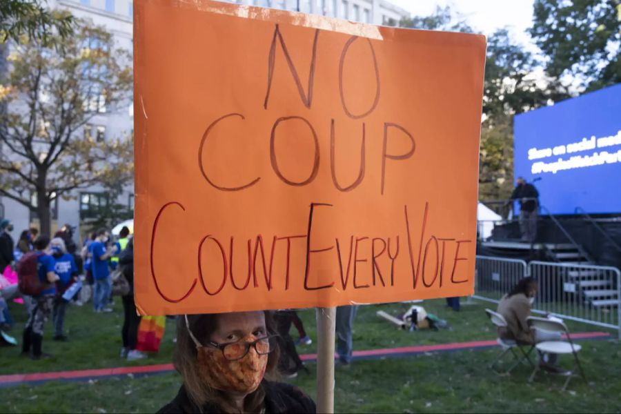 Eine Biden-Supporterin hält ein Schild mit der Aufschrift «No Coup – Count Every Vote» auf.