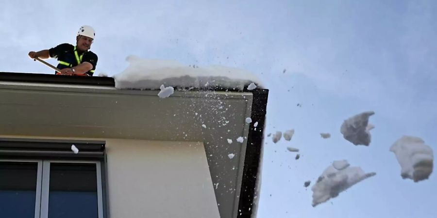 Hauseigentümer sind verpflichtet, Dachlawinen zu verhindern. Im Bild ein gesicherter Feuerwehrmann im März 2006 in Zürich. (Archivbild)