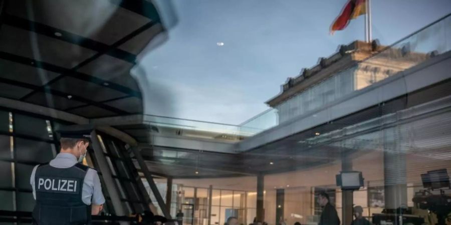 Ein uniformierter Polizist der Bundestags-Polizei beobachtet die Fraktionsebene im Deutschen Bundestag. Nach den Störungen von Bundestagsabgeordneten durch Gäste ist die Bundestagspolizei im Reichstagsgebäude häufiger zu sehen. Foto: Michael Kappeler/dpa