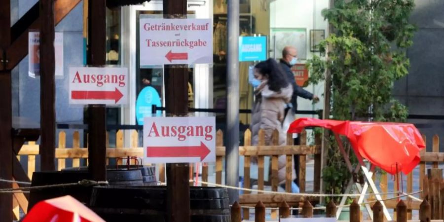 "Ausgang"-Schilder sind an einem geschlossenen Glühweinstand auf dem Weihnachtsmarkt Essen befestigt. Der Weihnachtsmarkt sollte eigentlich am 14. November 2020 starten, doch wegen Corona und des Teil-Lockdowns in Deutschland bleibt unklar, ob er in diesem Jahr öffnen werden kann. Foto: Roland Weihrauch/dpa
