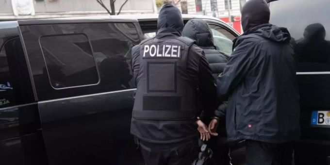 Polizisten führen einen Mann ab. Die Durchsuchungen stehen den Angaben zufolge im Zusammenhang mit Ermittlungen wegen des Verdachts der gewerbsmässigen Hehlerei und der gewerbsmässigen Geldfälschung. Foto: Paul Zinken/dpa Polizisten führen einen Mann ab. Die Durchsuchungen stehen den Angaben zufolge im Zusammenhang mit Ermittlungen wegen des Verdachts der gewerbsmässigen Hehlerei und der gewerbsmässigen Geldfälschung. Foto: Paul Zinken/dpa