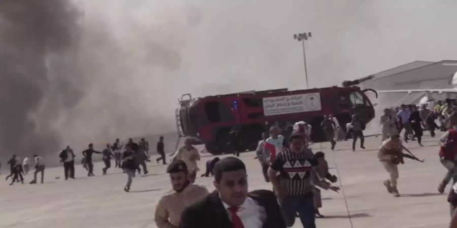 Menschen rennen nach einer schweren Explosion fluchtartig über den Flughafen der jemenitischen Stadt Aden. Bei einer schweren Explosion wurden nach offiziellen Angaben mindestens 16 Menschen getötet und Dutzende verletzt. Foto: --/AP/dpa