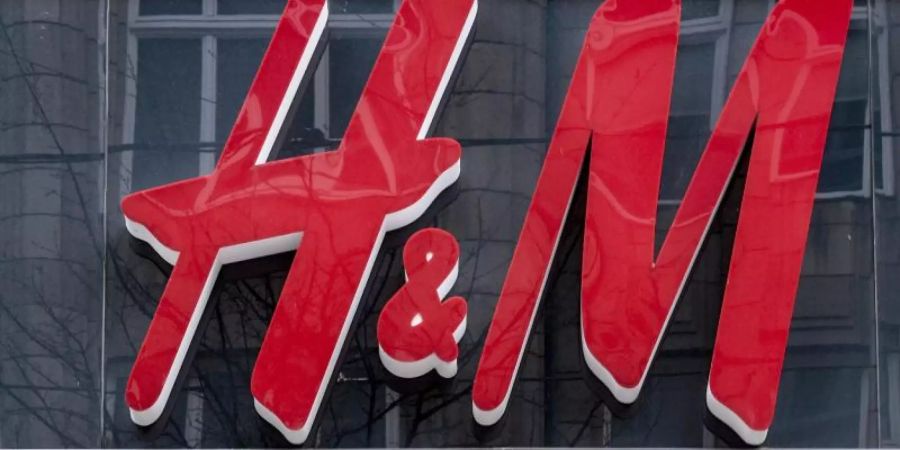 Das Logo der Modekette H&amp;M hängt über dem Eingang des Kaufhauses in der Hamburger Innenstadt. Foto: Axel Heimken/dpa