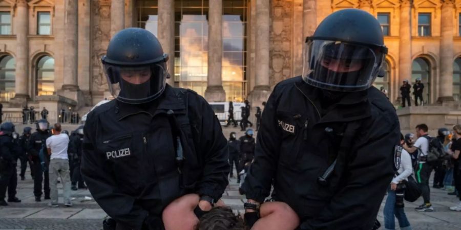 Polizisten führen Demonstranen vor dem Bundestagsgebäude ab