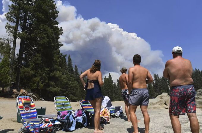 Eine Familie beobachtet den Waldbrand beim Campen. waldbrand