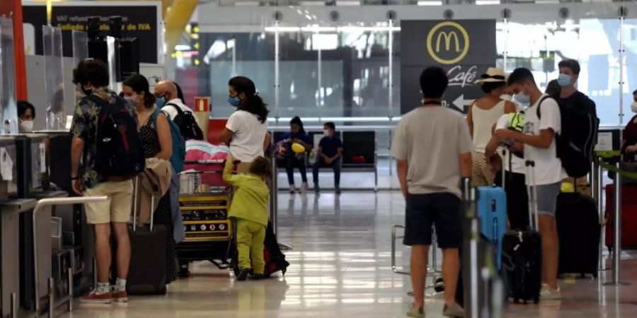 Reisende stehen an den Check-in-Schaltern im Terminal T1 des Flughafens in Madrid. Foto: Óscar Cañas/EUROPA PRESS/dpa