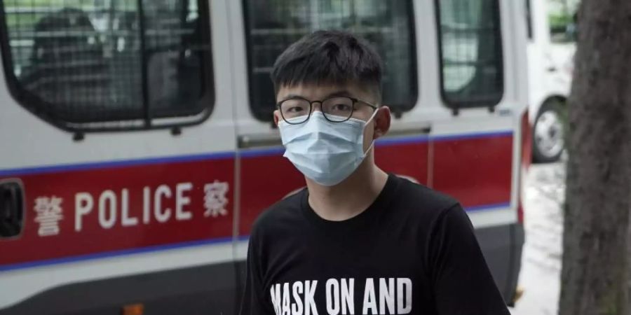 Der Hongkong-Aktivist Joshua Wong trifft mit Mund-Nasen-Schutz vor einem Gericht ein. Der bekannte Hongkonger Aktivist Wong rechnet damit, dass er zu einer Haftstrafe verurteilt wird. Foto: Kin Cheung/AP/dpa