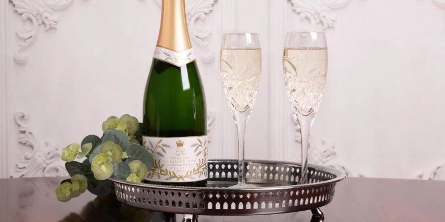 Undatiertes, vom Royal Collection Trust herausgegebenes Foto des Jubiläumssekts mit einem Paar handgeschliffener britischer Champagner-Flötengläser. Fans der britischen Königin können künftig mit offiziellem Jubiläumssekt aus dem Buckingham-Palast auf das Platinjubiläum der Queen anstossen. Foto: Royal Collection Trust/PA Media/dpa