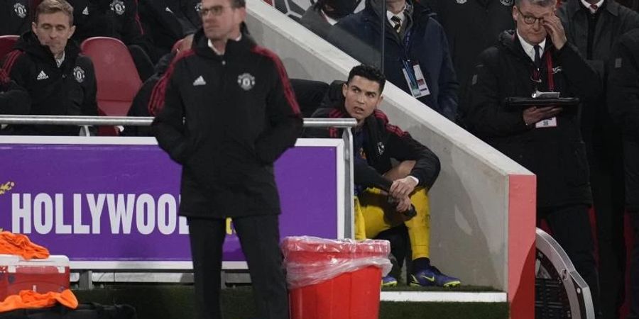 Manchester Uniteds Cristiano Ronaldo (M) verfolgt nach seiner Auswechslung durch Trainer Ralf Rangnick (v) das Spiel. Foto: Matt Dunham/AP/dpa