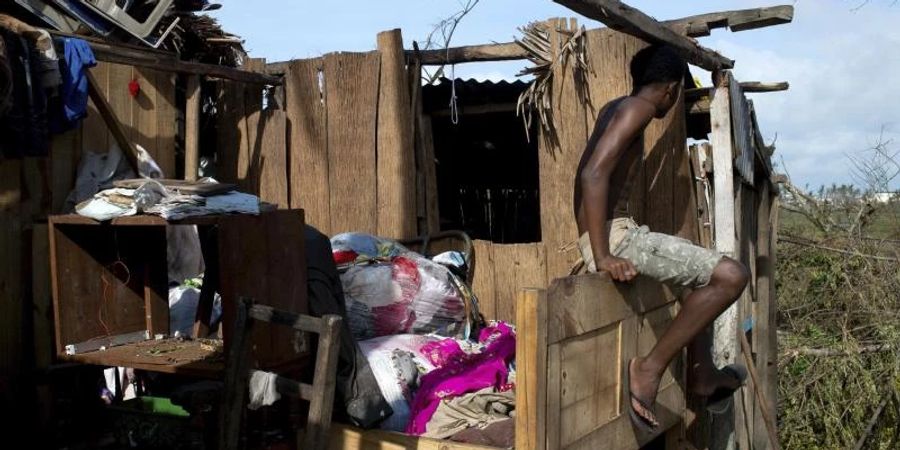 Ein Mann vor den Überresten eines Hauses. Foto: Viviene Rakotoarivony/AP/dpa