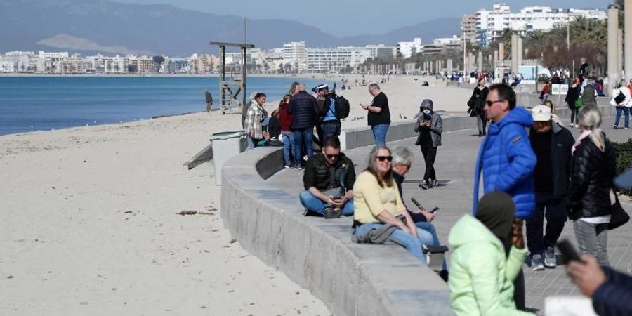 Touristen geniessen die Februarsonne auf Mallorca. Die Insel bereitet sich auf die Saison vor. Foto: Clara Margais/dpa