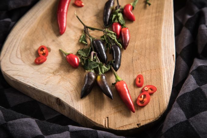 Die Farbe von Chilischoten sagt nichts über ihren Schärfegrad aus. Chilischoten Brett rot lilafarben