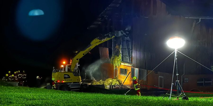 Die Feuerwehr Schüpfheim holt die Glutnester aus der Scheune und löscht diese fortzugehend.