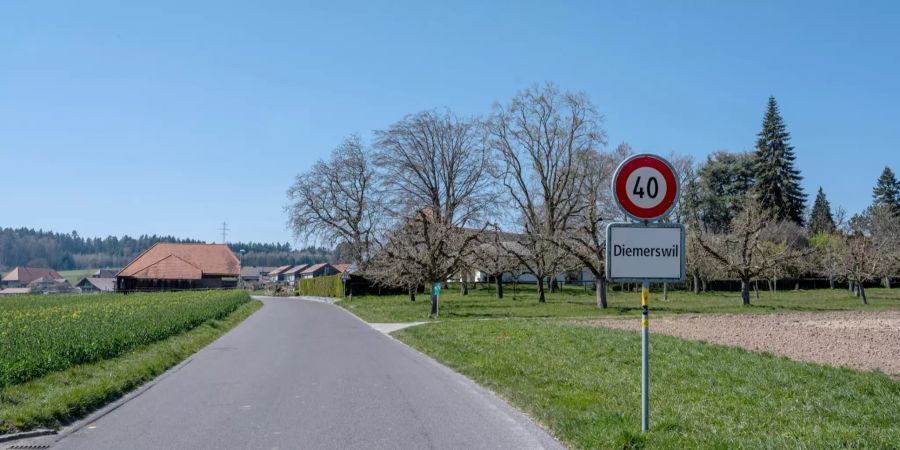 Ortstafel von Diemerswil mit dem Dorf Diemerswil im Hintergrund.