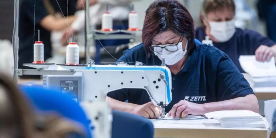 Ein Automobilzulieferer in Bayern hat auf die Produktion von Mundschutzmasken umgestellt. Foto: Armin Weigel/dpa