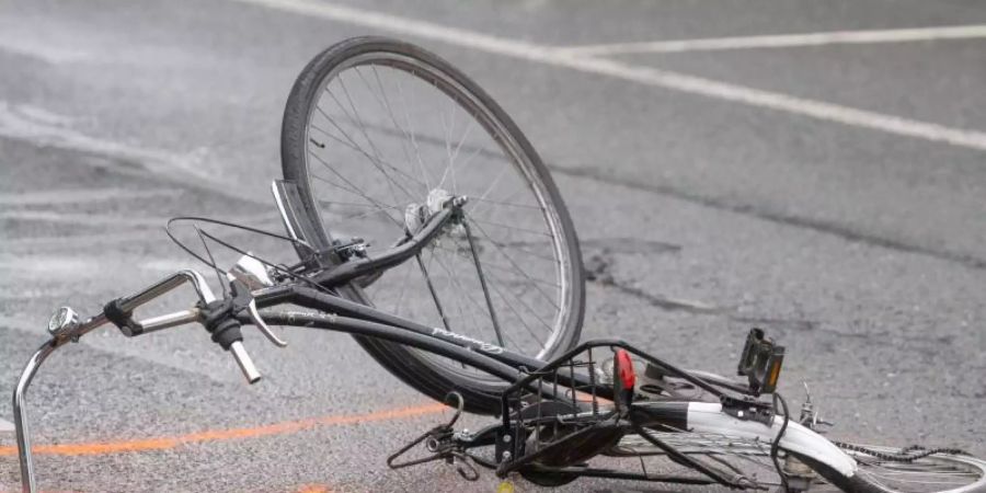 Nach einem Unfall liegt ein zerstörtes Fahrrad auf der Strasse. Nach Angaben des Verkehrssicherheitsrats waren 2018 29 Prozent aller bei Unfällen getöteten Verkehrsteilnehmer Fussgänger und Radfahrer. Foto: Arnulf Stoffel/dpa