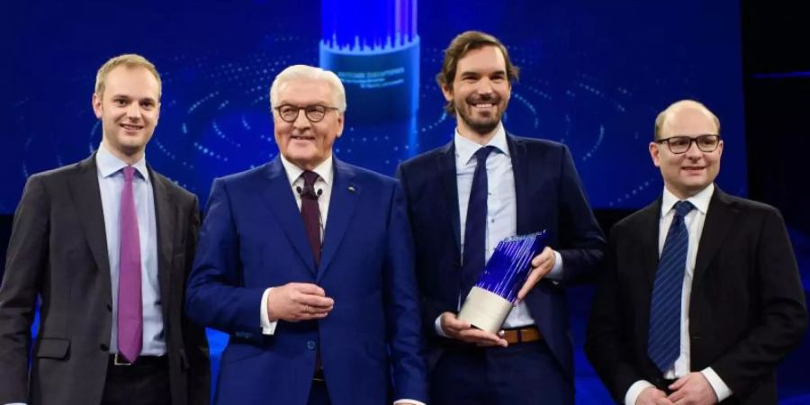 Frank-Walter Steinmeier (2.v.l.), Bundespräsident, steht gemeinsam mit den Preisträgern des deutschen Zukunftspreises, Alexander Rinke (l-r), Martin Klenk und Bastian Nominacher, nach der Verleihung auf der Bühne. Foto: Gregor Fischer/dpa