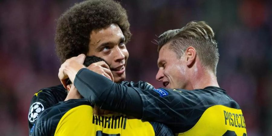 Axel Witsel (l) und Lukasz Piszczek (r) feiern Dortmunds Torschützen zur 1:0-Führung Achraf Hakimi. Foto: Guido Kirchner/dpa