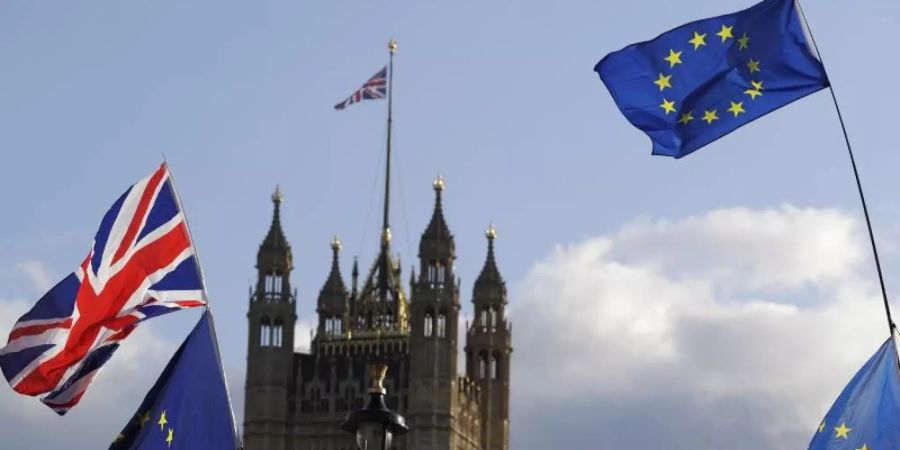 Die Flaggen von Grossbritannien und der Europäischen Union wehen vor dem britischen Parlament. Foto: Kirsty Wigglesworth/AP/dpa