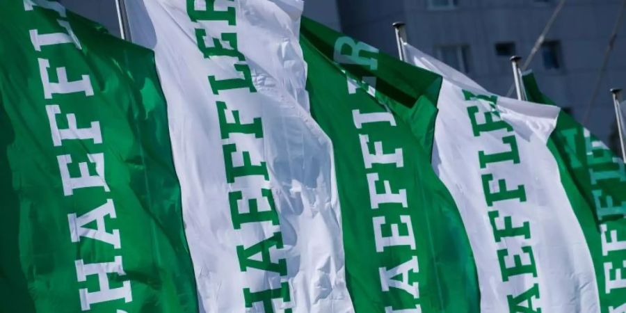 Fahnen mit dem Schriftzug der Schaeffler AG wehen am Rande der Hauptversammlung. Foto: Daniel Karmann/dpa