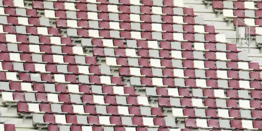 Ein Zuschauer sitzt alleine mit einer deutschen Nationalflagge auf der Zuschauertribüne im Khalifa-Stadion in Doha. Foto: Nariman El-Mofty/AP/dpa