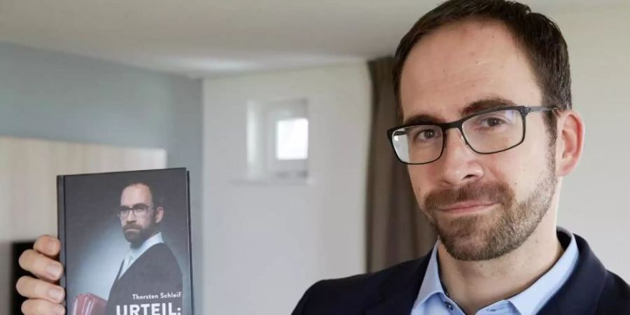 Amtsrichter Thorsten Schleif zeigt sein Buch mit dem Titel «Urteil ungerecht». Foto: Thomas Frey/dpa