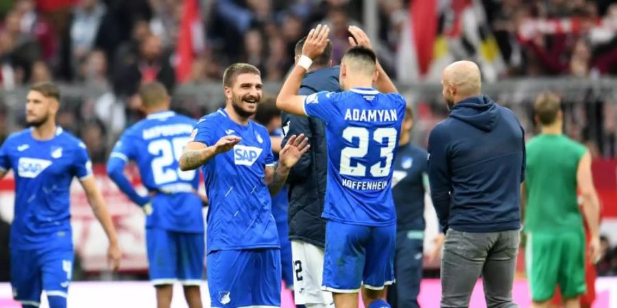 Hoffenheims Konstantinos Stafylidis (l) gratuliert Doppeltorschütze Sargis Adamyan zur Leistung gegen die Bayern. Foto: Tobias Hase/dpa