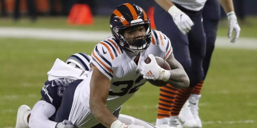 David Montgomery (vorne) setzte sich mit den Chicago Bears gegen Xavier Woods und dessen Dallas Cowboys durch. Foto: Charles Rex Arbogast/AP/dpa