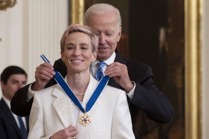 Joe Biden legt Megan Rapinoe eine Medaille um. joe biden