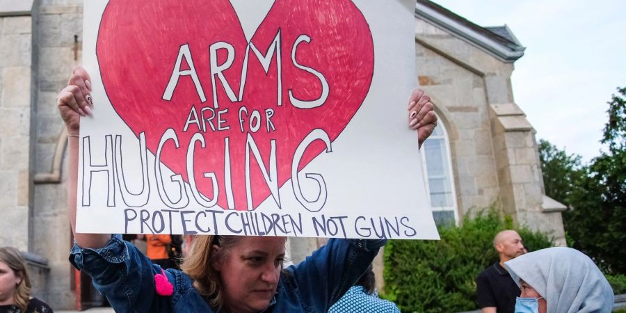 Ein Plakat, das danach fragt, wer in den USA geschützt wird: Kinder oder Waffen?