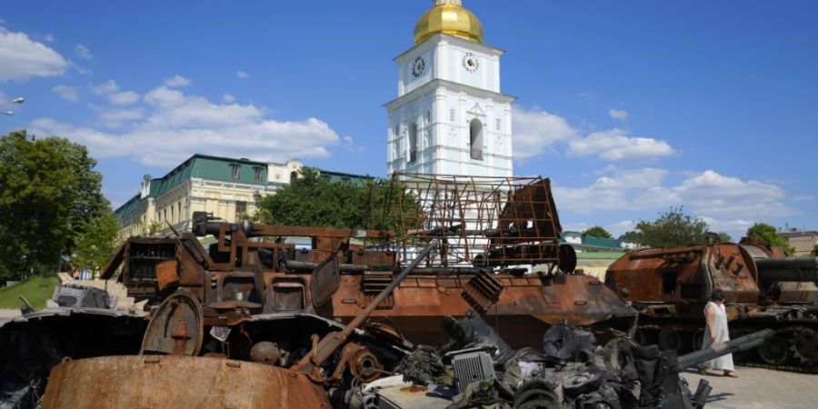 dpatopbilder - Eine Frau geht an einem zerstörten russischen Panzer in Kiew vorbei. Foto: Efrem Lukatsky/AP/dpa