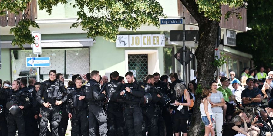 Polizisten suchen bei der Kundgebung vor der Demonstration des Bündnisses «Stop G7 Elmau» Schatten unter einem Baum.