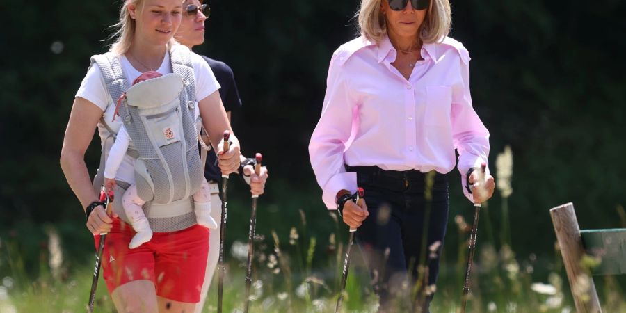 Miriam Neureuther (l-r) mit Kind in Babytrage, Amelie Derbaudrenghien (verdeckt dahinter), Partnerin von EU-Ratspräsident Charles Michel, und Brigitte Macron bei einer Nordic-Walking-Wanderung.