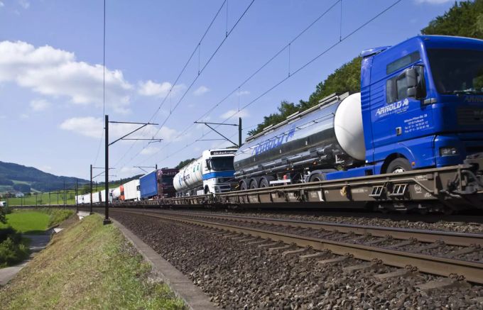 Eine Rollende Landstrasse (Rola) von HUPAC auf dem Weg nach Italien in Gelterkinden BL. Lastwagen LSVA Schiene Alpen