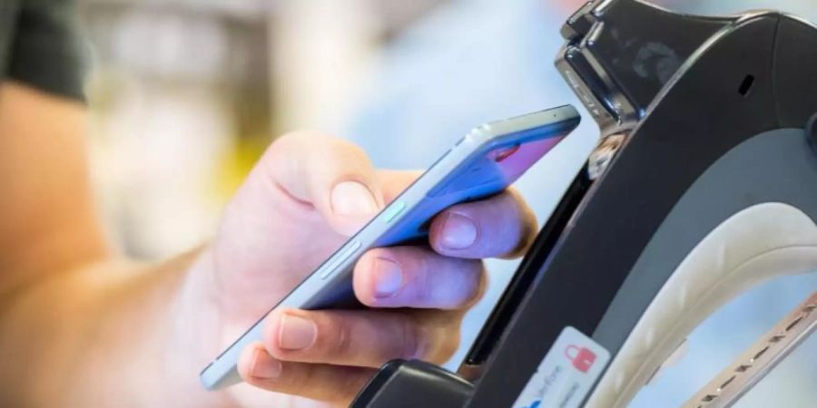 Ein Smartphone wird an ein Kassenterminal gehalten. Mit der entsprechenden App kann man so bezahlen.). Foto: Franziska Gabbert/dpa-tmn/dpa