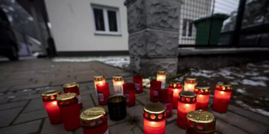 Kerzen vor dem Einfamilienhaus in Königs Wusterhausen, in dem die Toten gefunden wurden. Foto: Fabian Sommer/dpa