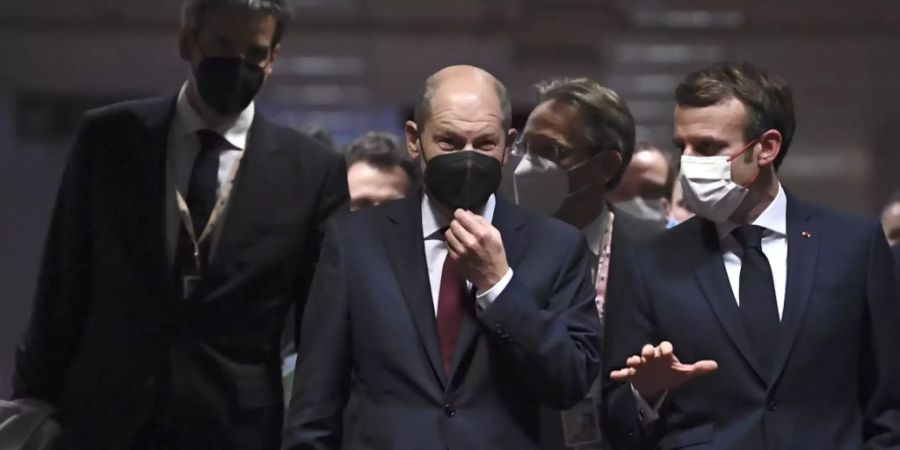 Olaf Scholz (M), Deutschlands Bundeskanzler, und Emmanuel Macron (r), Präsident von Frankreich, gehen vor einer abschliessenden Pressekonferenz auf dem EU-Gipfel über einen Flur. Foto: John Thys/Pool AFP/dpa