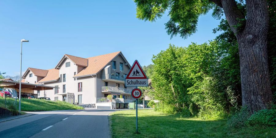 Altes (Holzhaus rechts) und neues Schulhaus (rechts) in Gurzelen. Hinten die Gemeindeverwaltung.