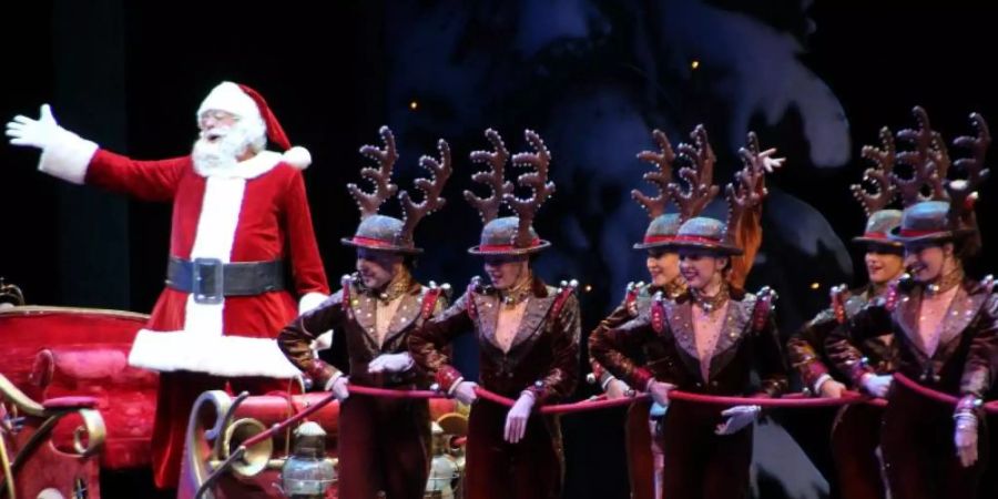 Mitglieder der Tanztruppe «Rockettes» ziehen während einer Aufführung im Jahr 2018 einen Schlitten mit einem Weihnachtsmann über die Bühne. Foto: Christina Horsten/dpa