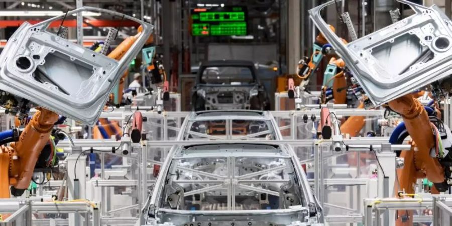 Maschine statt Mensch: Roboter montieren Türen eines Autos. Foto: Hendrik Schmidt/dpa