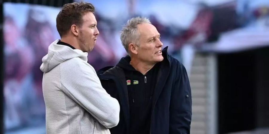 Schätzen sich gegenseitig: Bayern-Trainer Julian Nagelsmann (l) und Freiburg-Coach Christian Streich. Foto: Hendrik Schmidt/dpa-Zentralbild/ZB