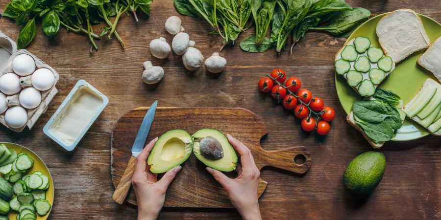 frau schneidet avocado