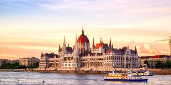 Das ungarische Parlamentsgebäude an der Donau in Budapest bei Sonnenuntergang.