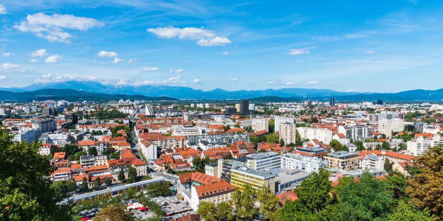 Ljubljana von oben fotografiert, mit Bergen im Hintergrund.