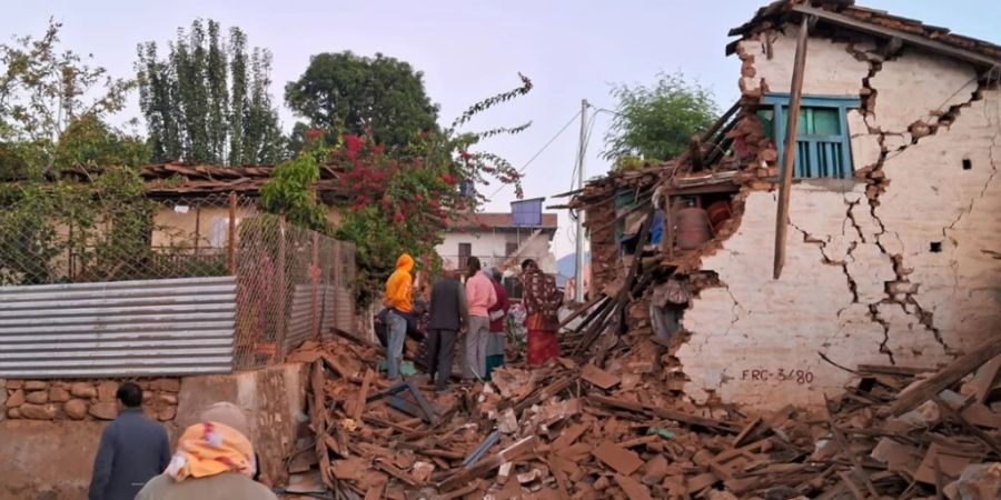 HANDOUT - Menschen suchen in den Trümmern nach ihren Habseligkeiten. Foto: Sunil Sharma/ZUMA Press Wire/dpa