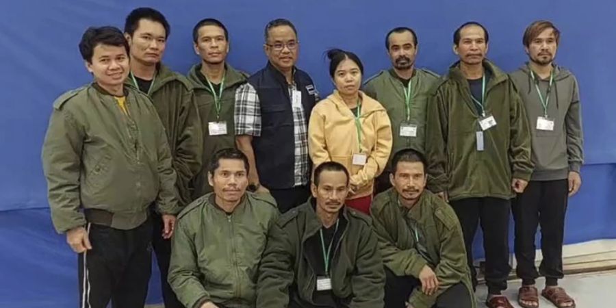 Zehn Geiseln der Hamas, die am Freitag befreit wurden, und ein thailändischer Beamter posieren für ein Foto in Israel. Am Samstag wurden vier weitere thailändische Staatsangehörige befreit.